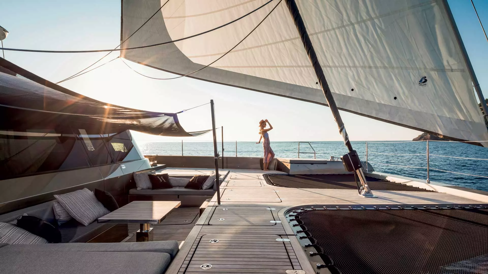 Forward deck of a Sunreef luxury sailing catamaran at sunset.